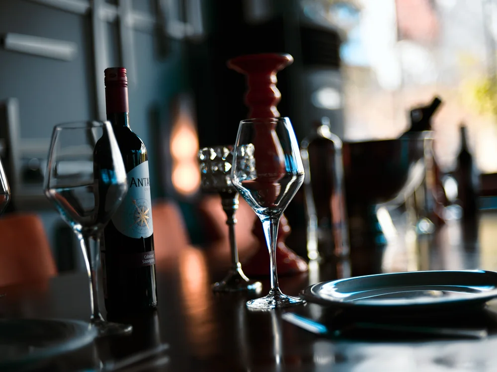 Wine glasses and a bottle set on a restaurant table